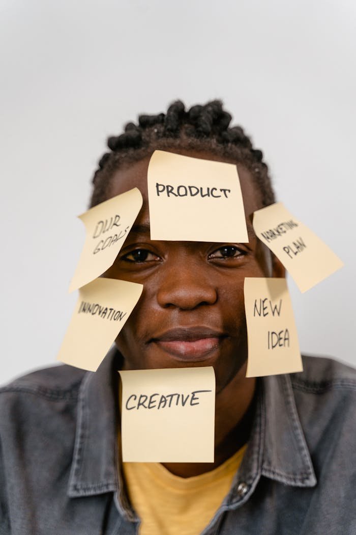 trusted-partner Creative representation of brainstorming ideas with sticky notes on man's face for innovation and planning.