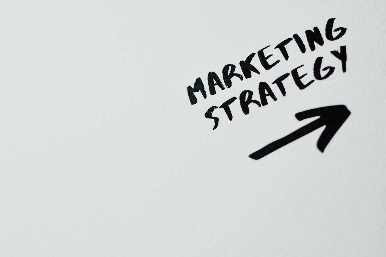 about-img Close-up of handwritten 'Marketing Strategy' text with an arrow on white background.